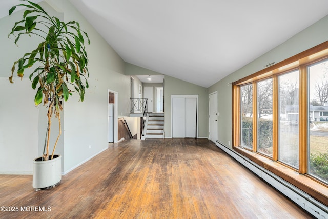 unfurnished living room featuring baseboard heating, hardwood / wood-style floors, and vaulted ceiling