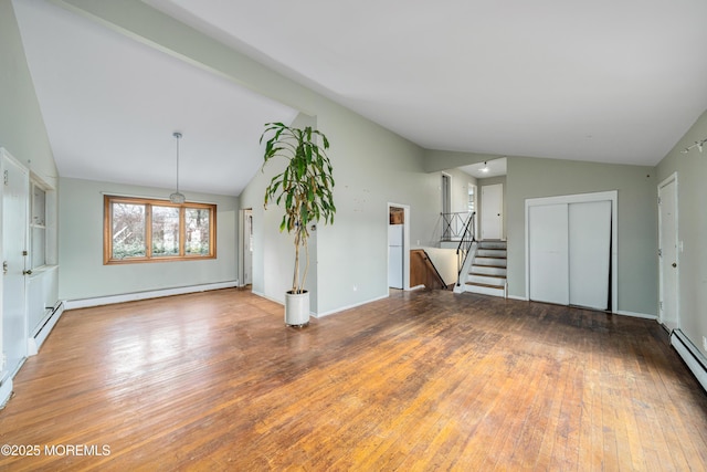 unfurnished living room with baseboard heating, vaulted ceiling, and hardwood / wood-style flooring