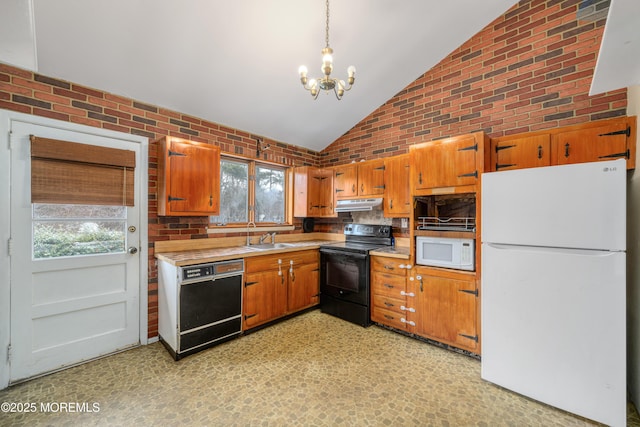 kitchen featuring a wealth of natural light, brick wall, black appliances, pendant lighting, and lofted ceiling