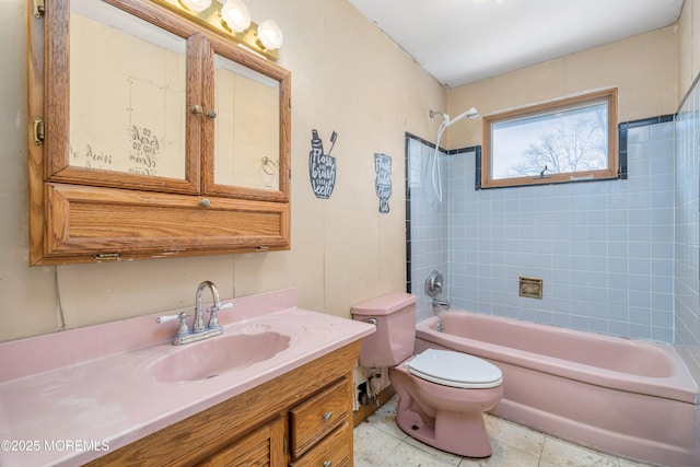 full bathroom with tile patterned flooring, vanity, tiled shower / bath combo, and toilet