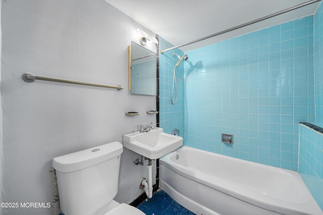 bathroom featuring toilet and tiled shower / bath