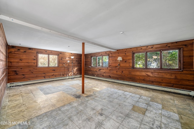 empty room featuring wood walls, beam ceiling, and a baseboard heating unit