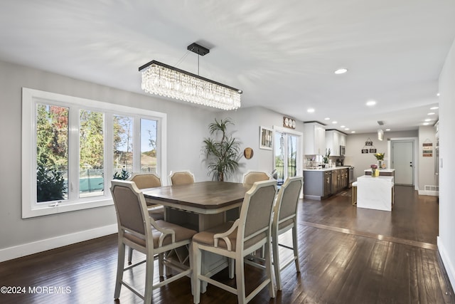 dining space with dark hardwood / wood-style flooring and an inviting chandelier