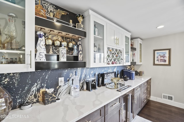 bar with white cabinetry, beverage cooler, light stone counters, dark hardwood / wood-style flooring, and backsplash