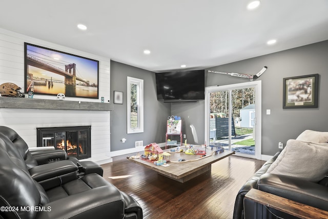 living room featuring hardwood / wood-style flooring and a large fireplace