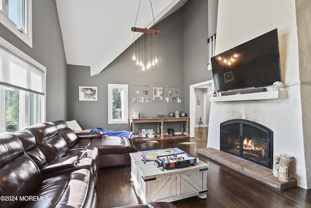 living room with high vaulted ceiling, dark wood-type flooring, and a tiled fireplace