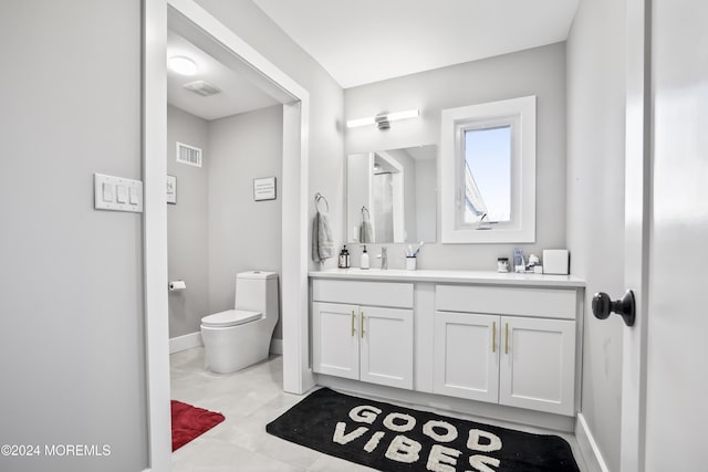 bathroom with tile patterned flooring, vanity, and toilet