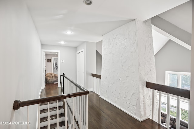 hall featuring wood-type flooring and lofted ceiling