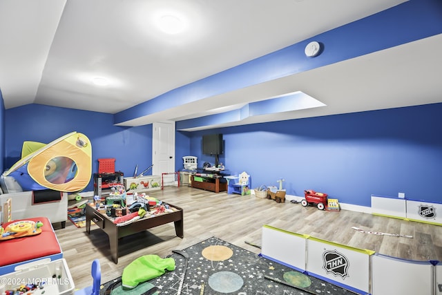 playroom featuring light hardwood / wood-style flooring and lofted ceiling