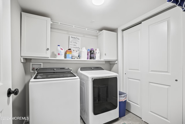 washroom featuring washer and dryer and cabinets