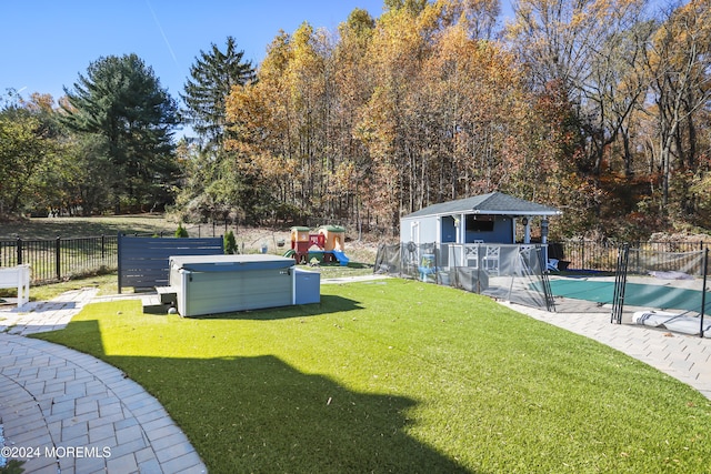 view of yard with a playground and a pool with hot tub