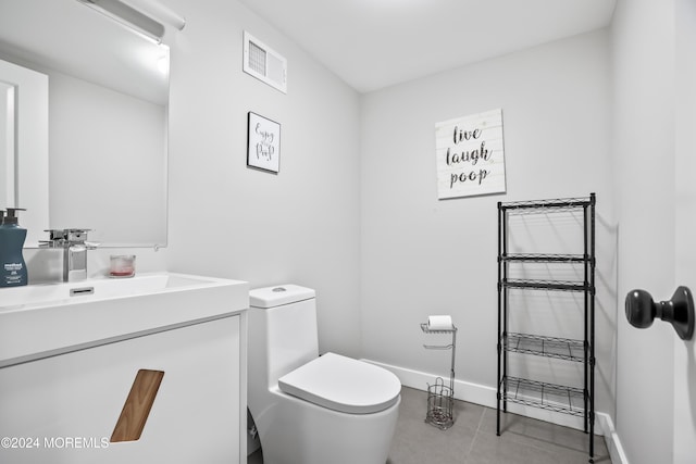 bathroom featuring tile patterned flooring, vanity, and toilet