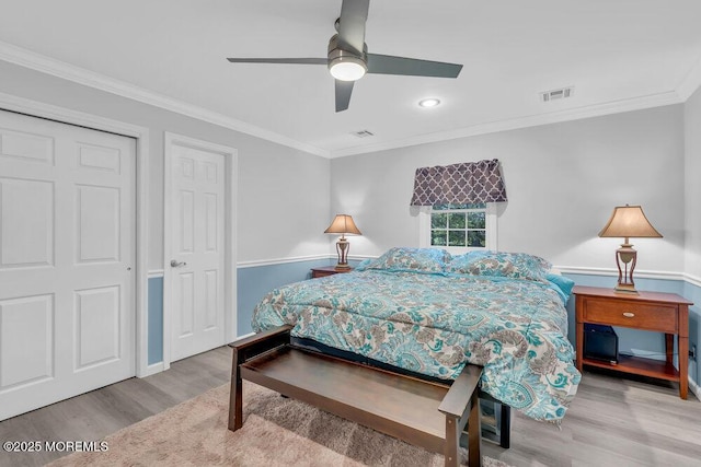 bedroom with ceiling fan, baseboards, wood finished floors, visible vents, and ornamental molding