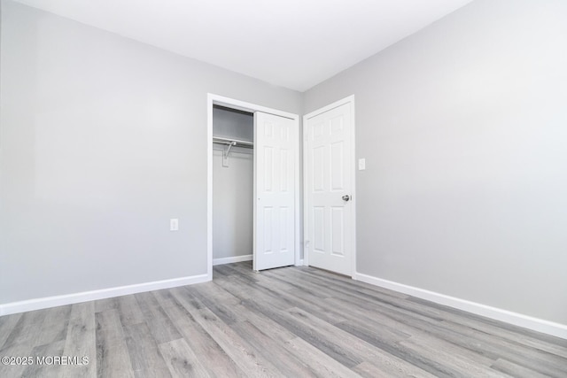 unfurnished bedroom featuring light hardwood / wood-style floors and a closet