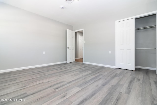 unfurnished bedroom featuring light hardwood / wood-style floors and a closet