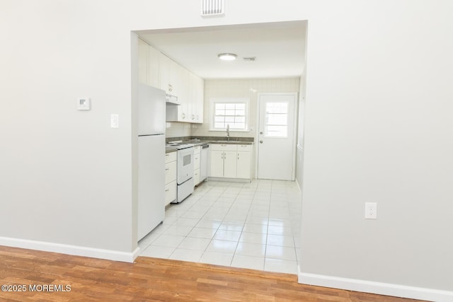 kitchen featuring white cabinetry, sink, ventilation hood, white appliances, and light tile patterned floors