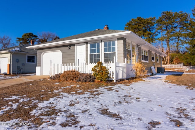 view of front of property featuring a garage and central air condition unit