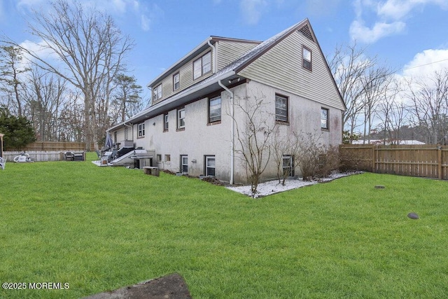 rear view of house featuring a lawn