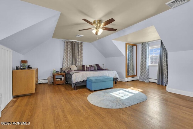 bedroom with vaulted ceiling, ceiling fan, baseboard heating, and light hardwood / wood-style floors