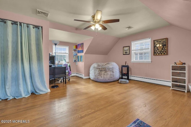 sitting room featuring ceiling fan, a baseboard heating unit, light wood-type flooring, and vaulted ceiling