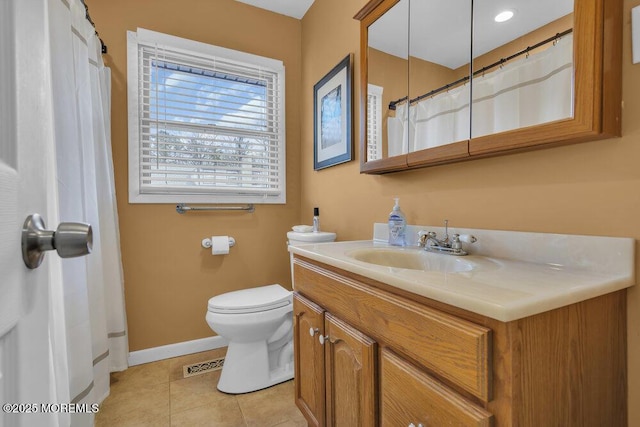 bathroom with toilet, vanity, and tile patterned flooring