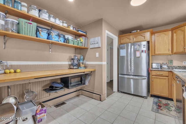 kitchen with light stone counters, light brown cabinets, stainless steel appliances, and light tile patterned flooring