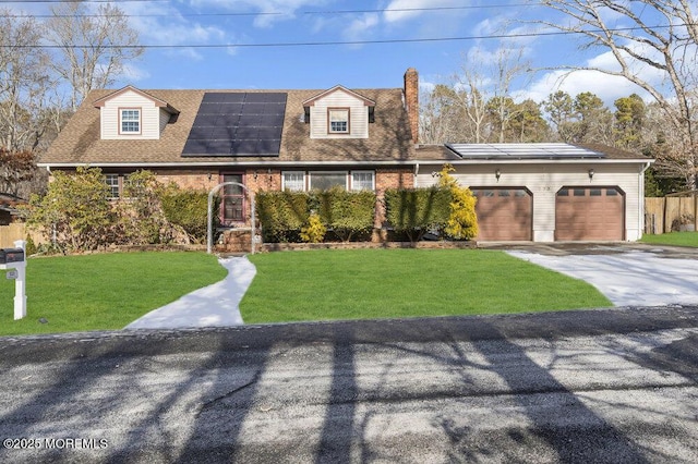 cape cod home featuring a front yard, a garage, and solar panels