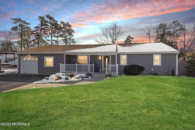 ranch-style home with a lawn, a porch, and a garage