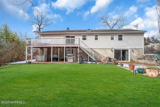 rear view of property with a patio, a lawn, and a wooden deck