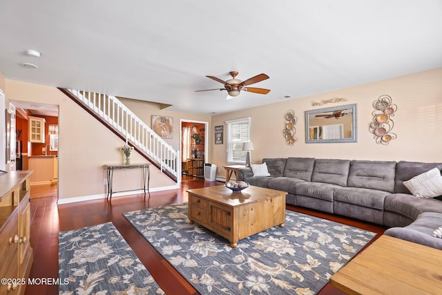 living room featuring ceiling fan and dark wood-type flooring