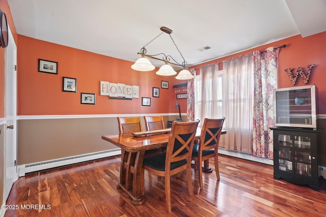 dining room with baseboard heating and hardwood / wood-style flooring