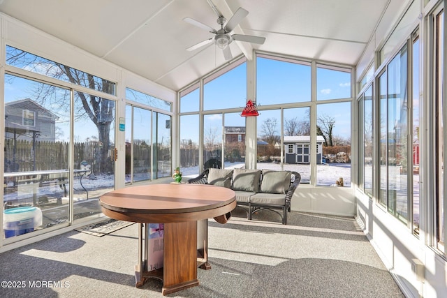 sunroom with a healthy amount of sunlight, ceiling fan, and lofted ceiling