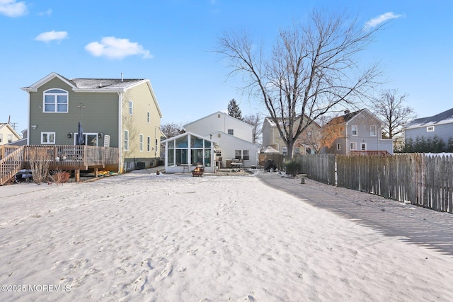 back of house featuring a wooden deck and a sunroom