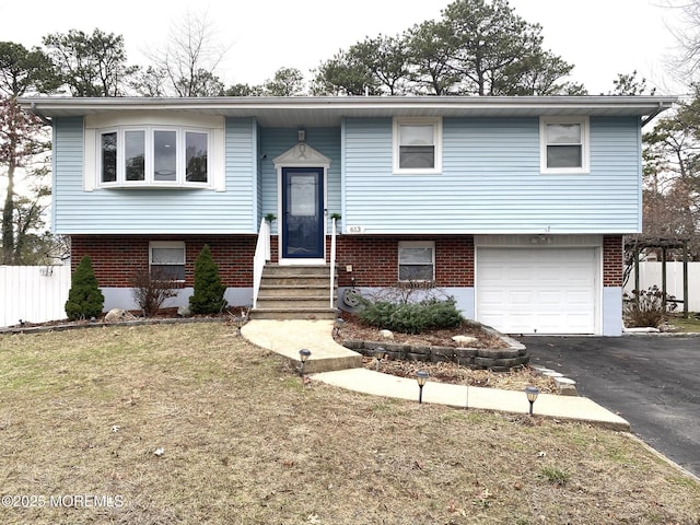 split foyer home featuring a garage and a front lawn