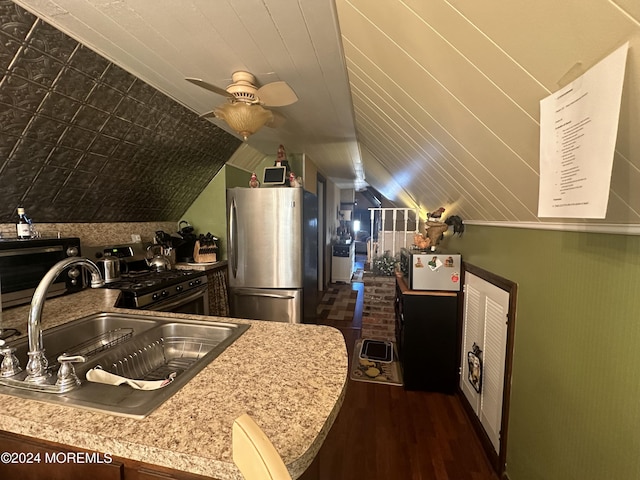 kitchen with sink, vaulted ceiling, ceiling fan, dark hardwood / wood-style flooring, and stainless steel appliances