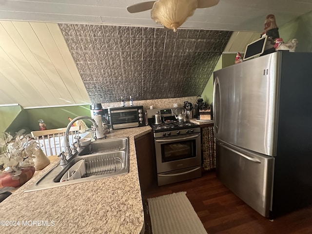 kitchen featuring dark hardwood / wood-style flooring, sink, appliances with stainless steel finishes, and vaulted ceiling