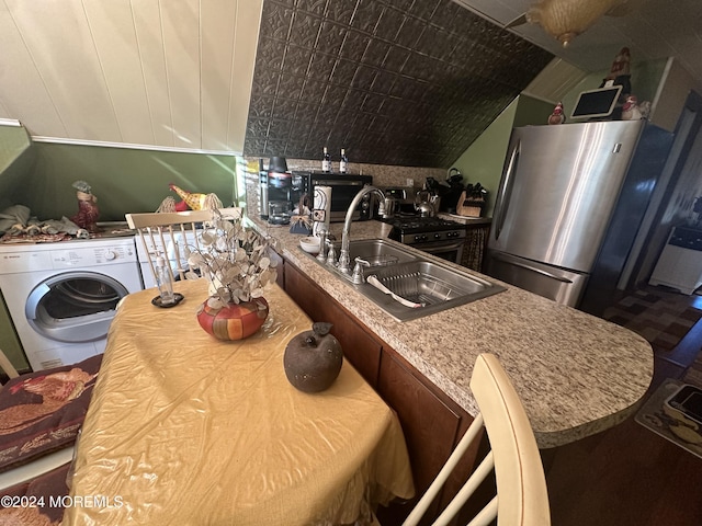 kitchen featuring stainless steel refrigerator, washer / clothes dryer, light stone countertops, and sink