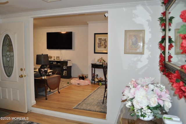 foyer entrance with hardwood / wood-style flooring and crown molding