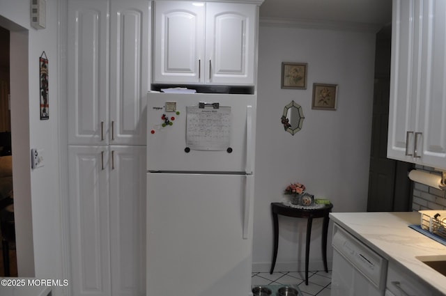 kitchen featuring white cabinetry, light stone counters, crown molding, white appliances, and light tile patterned floors