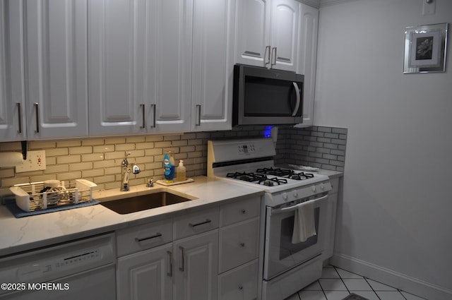 kitchen with white cabinets, backsplash, white appliances, and sink