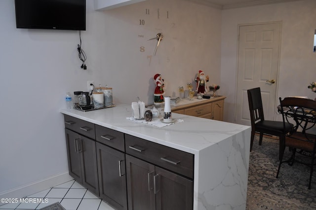 bar featuring light stone countertops, light tile patterned floors, crown molding, and dark brown cabinetry