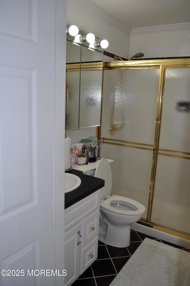 bathroom featuring tile patterned flooring, crown molding, an enclosed shower, toilet, and vanity