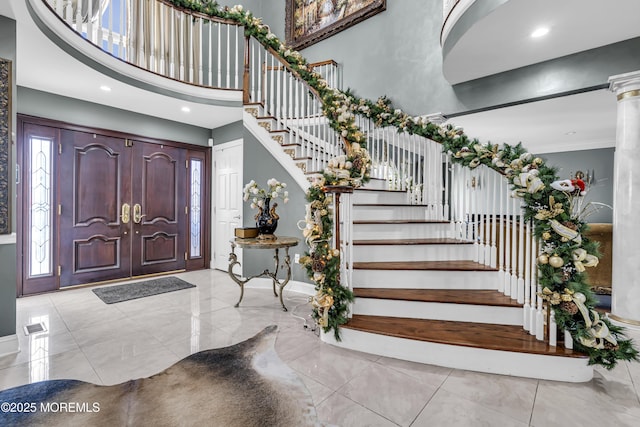 entryway with a towering ceiling and crown molding