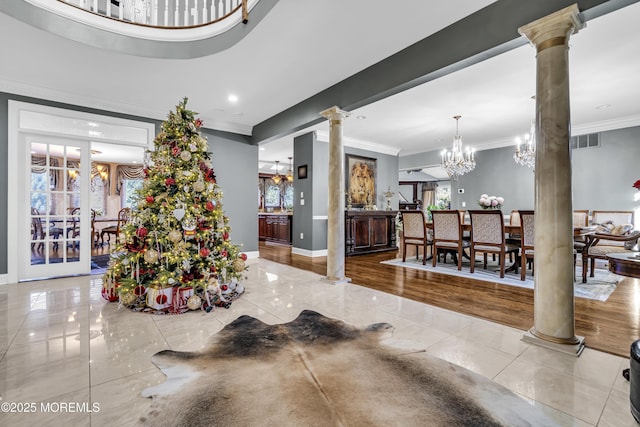 dining space featuring a chandelier, ornamental molding, and decorative columns