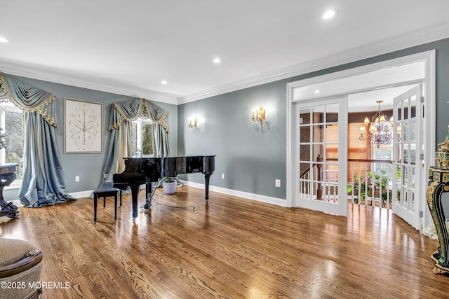 miscellaneous room featuring hardwood / wood-style floors, a notable chandelier, and crown molding