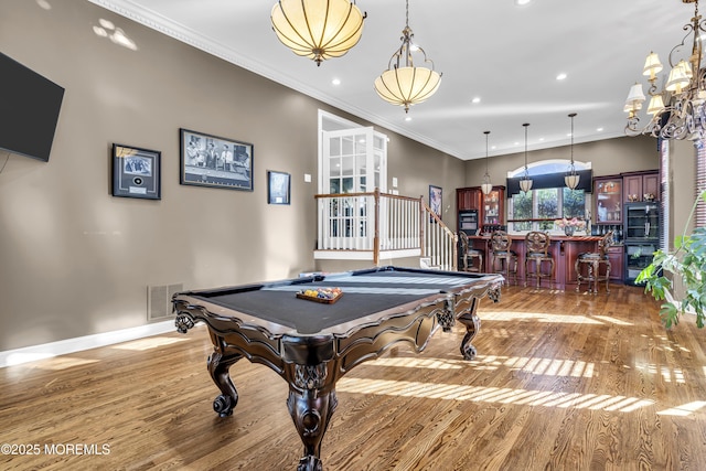 recreation room with crown molding, hardwood / wood-style floors, indoor bar, and billiards