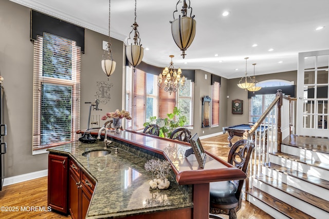 kitchen with ornamental molding, dark stone counters, sink, light hardwood / wood-style flooring, and billiards