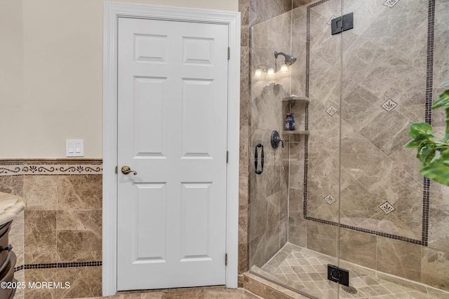 bathroom with vanity, tile walls, and a shower with shower door