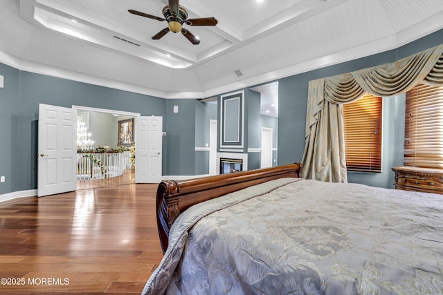 bedroom with beam ceiling, ceiling fan, ornamental molding, and hardwood / wood-style flooring