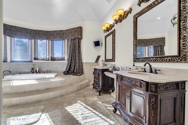 bathroom featuring tile patterned floors, vanity, tiled bath, and vaulted ceiling